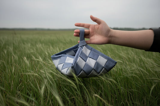 Hand holding a chess bag against a dark background
