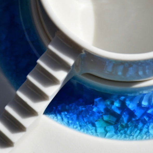 Close-up of Castle Coffee Set with porcelain cup and blue glass saucer