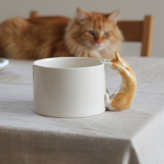White ceramic mug with a  genger cat handle on table